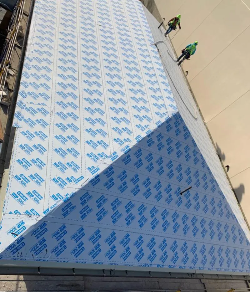 Professional roofers installing underlayment on a metal roof in New Baltimore